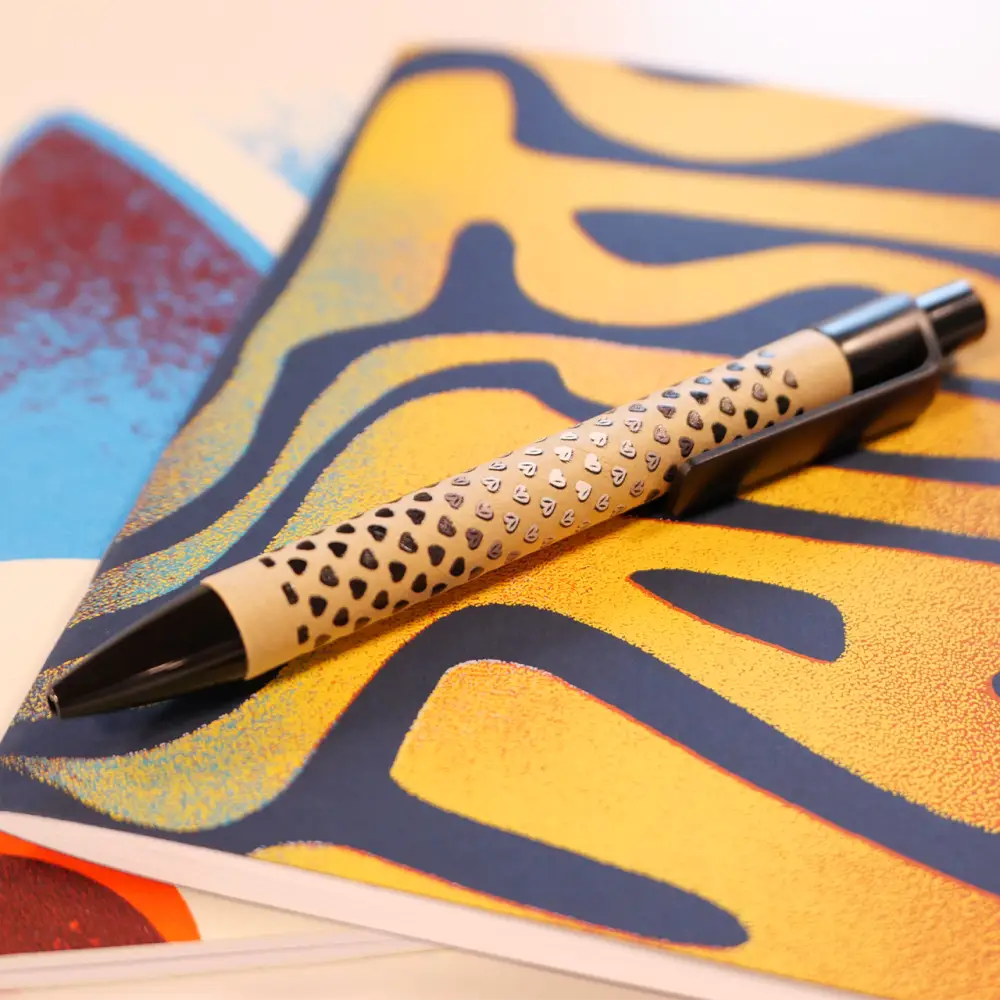 Decorative wooden pen with a pattern of small holes drilled into its barrel.