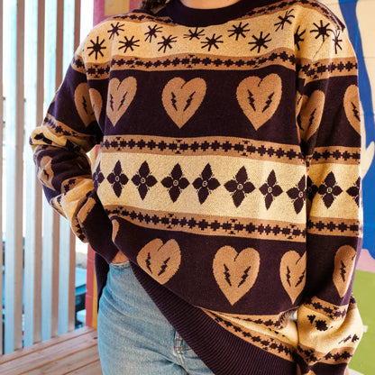 Patterned knit sweater with heart and floral motifs in brown and cream colors.