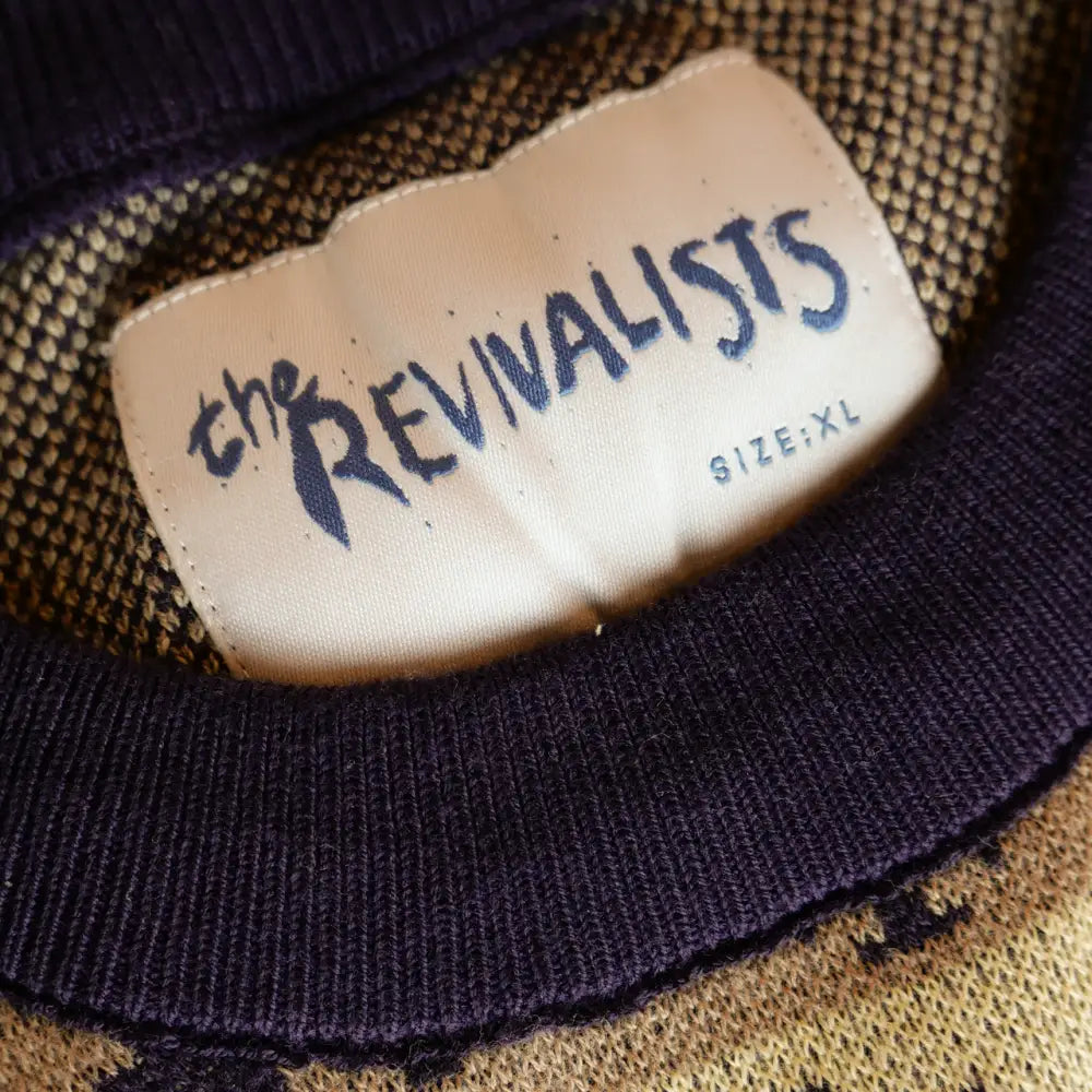 Clothing label reading ’The Revivalists’ with ’SIZE XL’ underneath.