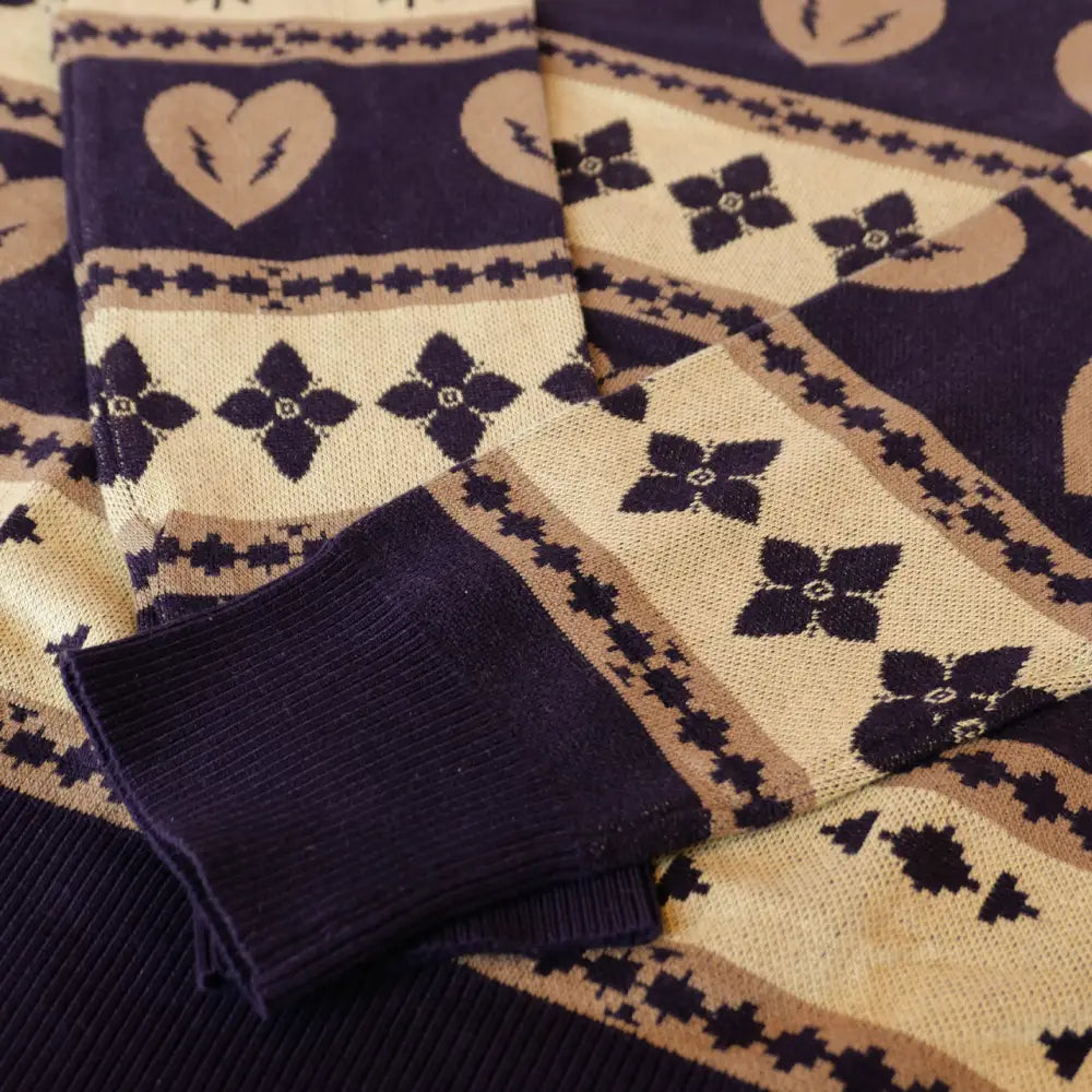 Patterned knit fabric with heart and floral motifs in navy blue and cream colors.