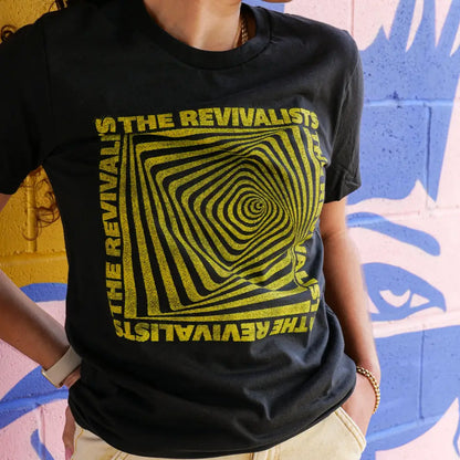 Black t-shirt with yellow psychedelic spiral design and text reading ’The Revivalists’.