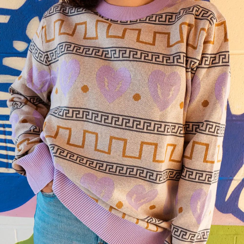 Patterned sweater with Greek key and geometric designs in pastel colors.