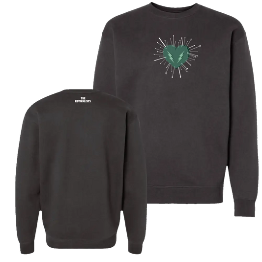 Dark gray crewneck sweatshirt featuring a green heart with lightning bolt and white radiating lines on the front, branded ’the revivalists’ at the back.