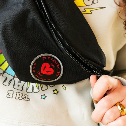 Black fanny pack with a red heart logo patch.