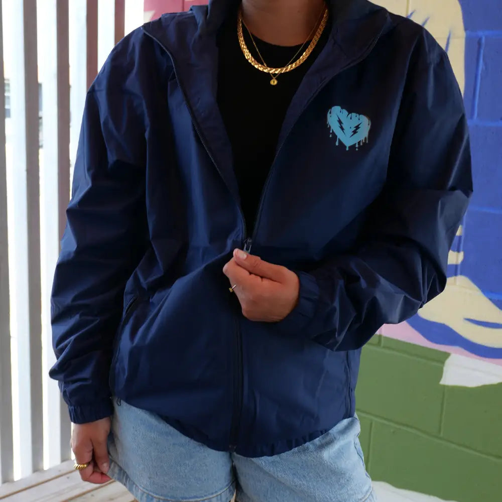 Navy blue zip-up jacket with a light blue heart logo on the chest.