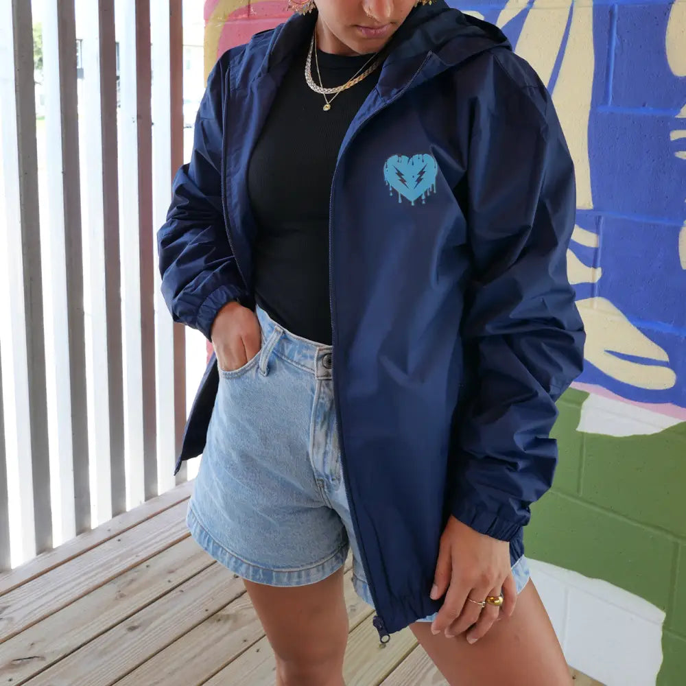 Navy blue windbreaker jacket with a light blue heart logo on the chest.